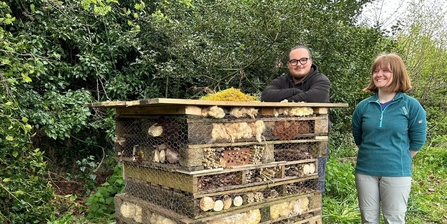 2 people standing next to bug hotel